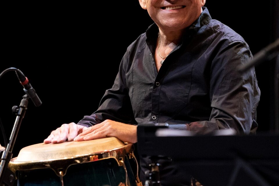 Ein Musiker spielt eine Conga-Trommel auf der Bühne. Er lächelt und hat eine positive Ausstrahlung. | © @Josef Steger