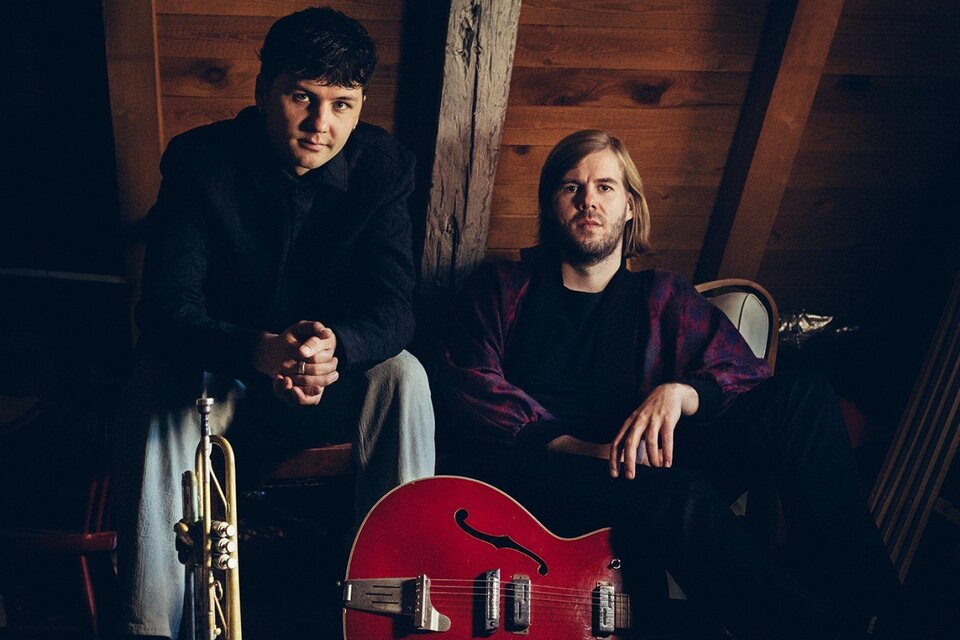 Zwei Musiker sitzen in einem rustikalen Raum. Einer hält eine Trompete und der andere eine rote Gitarre. | © jazzfestival