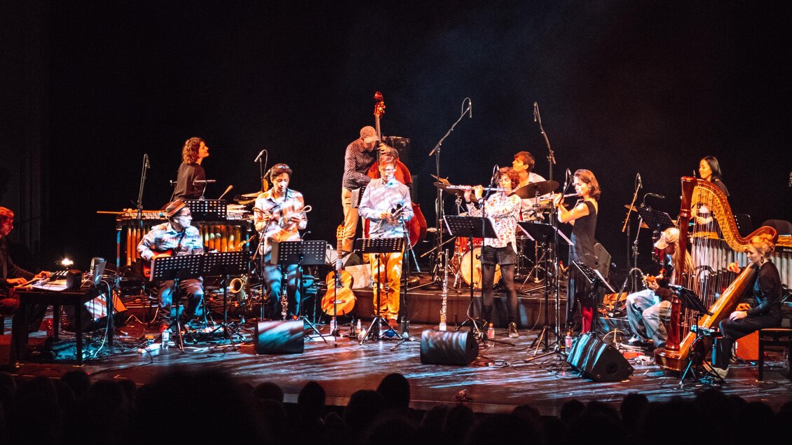 Eine Musikgruppe spielt auf einer Bühne. Es sind verschiedene Instrumente und Musiker zu sehen, die gemeinsam eine Aufführung genießen. | © jazzfestival