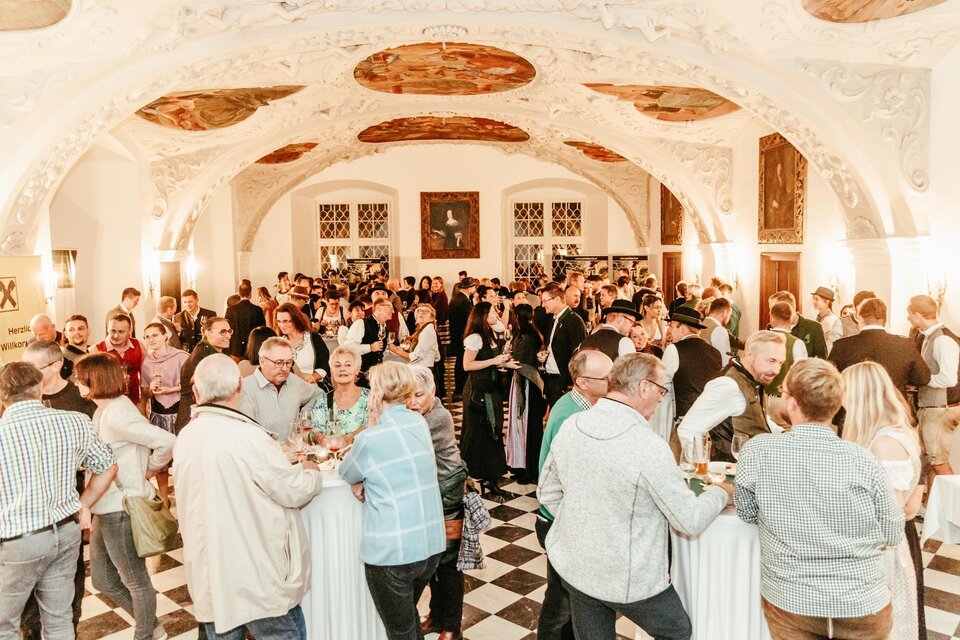 Eine lebhafte Veranstaltung in einem eleganten Raum mit vielen Gästen. Die Leute schätzen Gesellschaft und genießen Getränke in festlicher Atmosphäre. | © CDM Claudia Dunst