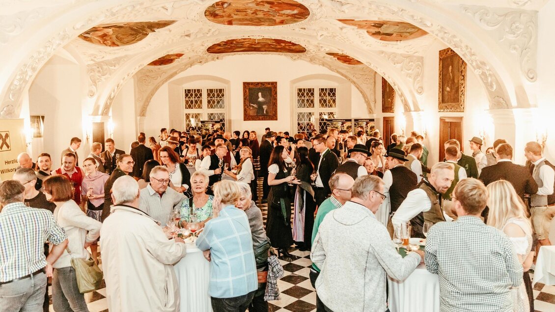 Eine lebhafte Veranstaltung in einem eleganten Raum mit vielen Gästen. Die Leute schätzen Gesellschaft und genießen Getränke in festlicher Atmosphäre. | © CDM Claudia Dunst