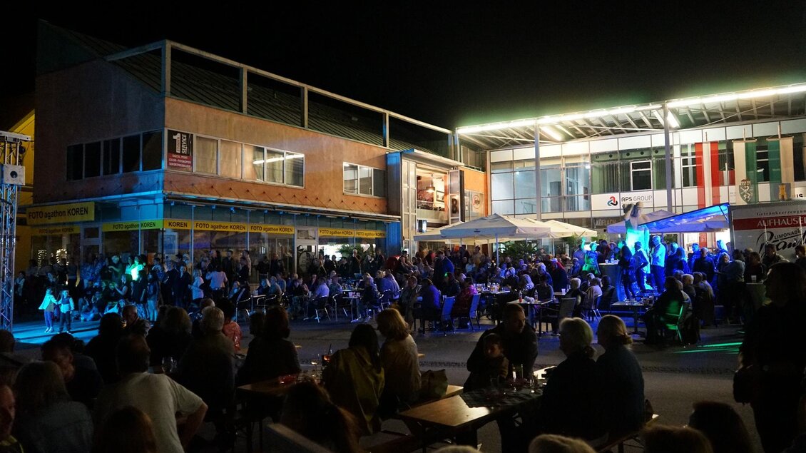 Eine lebhafte Nachtveranstaltung mit einer großen Menschenmenge. Die Atmosphäre ist festlich, beleuchtet von bunten Lichtern. | © Stadtgemeinde Köflach