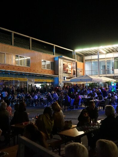 Eine lebhafte Nachtveranstaltung mit einer großen Menschenmenge. Die Atmosphäre ist festlich, beleuchtet von bunten Lichtern. | © Stadtgemeinde Köflach