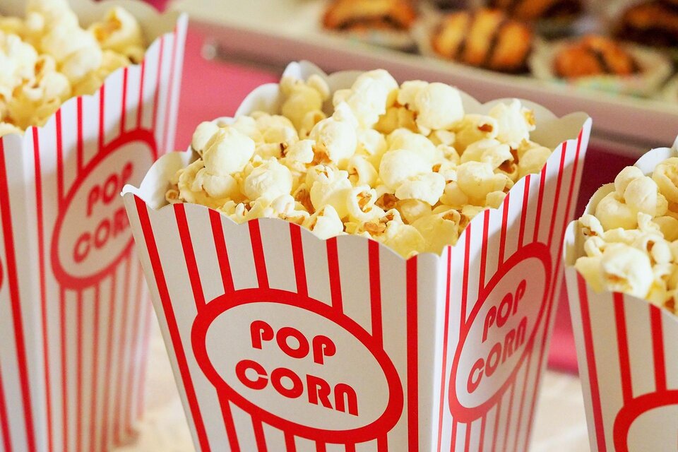 Eine Gruppe von Popcorntüten mit roten und weißen Streifen. Die Tüten sind gefüllt mit frisch zubereitetem Popcorn. | © Pixabay