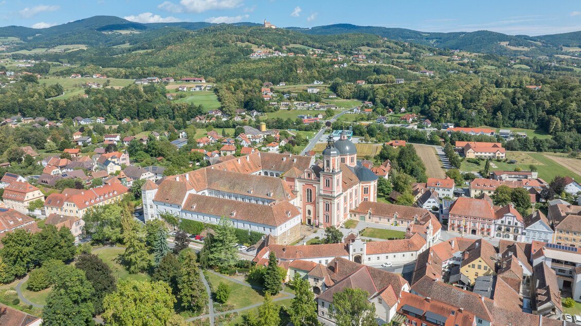Eine beeindruckende Aussicht auf eine Stadt mit historischen Gebäuden und grünen Hügeln im Hintergrund. Die Architektur und die Landschaft schaffen eine idyllische Atmosphäre. | © Helmut Schweighofer
