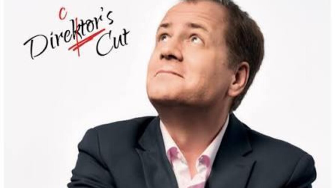 Ein Mann blickt nachdenklich nach oben und trägt einen Anzug. Der Schriftzug „Stefan Haider – Direktor's Cut“ ist deutlich sichtbar. | © Pressefoto Plakat Director's Cut © Roman Pfeiffer