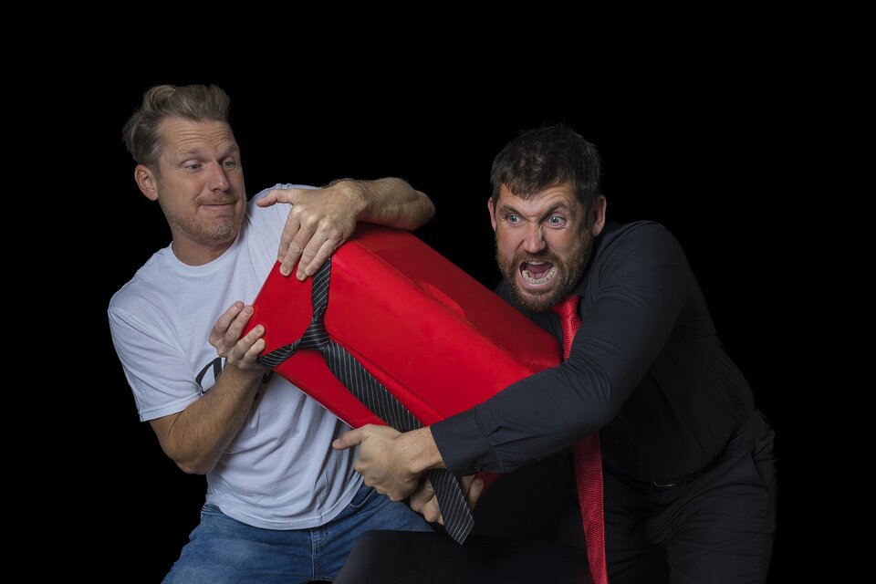 Zwei Kabarettisten mit rotem Kühlschrank in einer humorvollen Szene aus „Therapie Deluxe“ im Volkshaus Frohnleiten. | © Richard Weiß