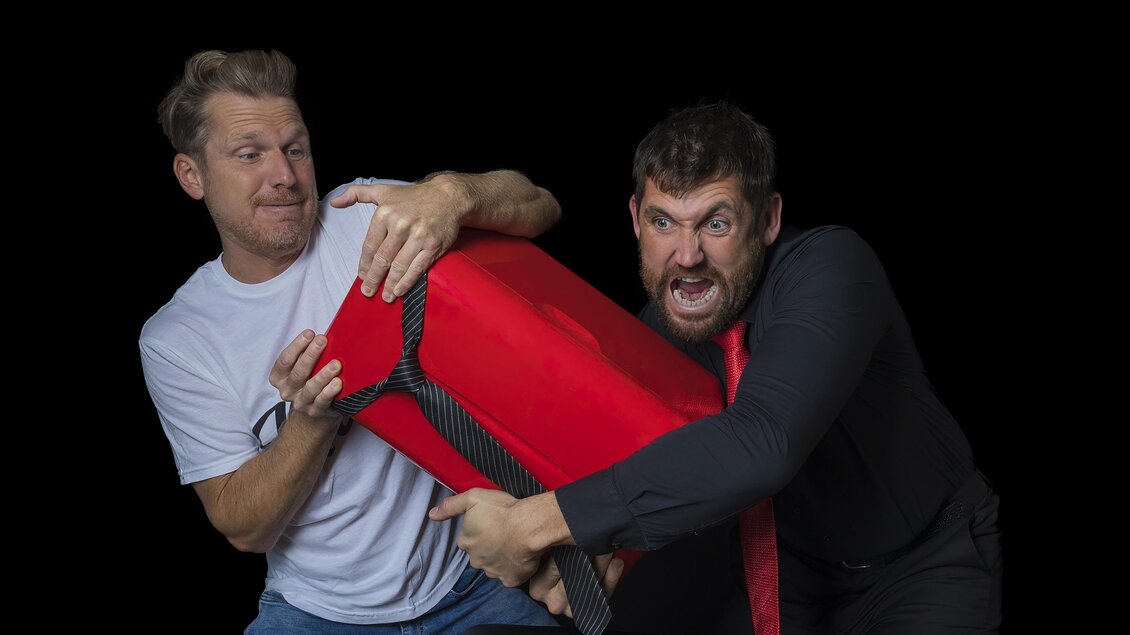 Zwei Kabarettisten mit rotem Kühlschrank in einer humorvollen Szene aus „Therapie Deluxe“ im Volkshaus Frohnleiten. | © Richard Weiß