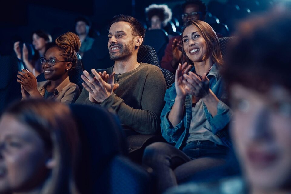 Eine Gruppe von Menschen sitzt in einem dunklen Raum und applaudiert. Sie scheinen begeistert und genießen die Atmosphäre. | © TV Südsteiermark - Adobe Stock