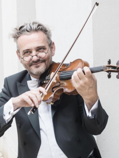 Johannes Meissl plays the violin during the chamber music festival at the Stift Rein, wearing a classic tailcoat and a smile on his face. | © Sabine Hauswirth