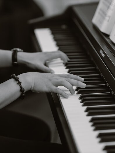 Eine Person spielt Klavier mit beiden Händen. Die Tasten sind schwarz und weiß, und zahlreiche Noten sind auf dem Stand ausgelegt. | © Pixabay