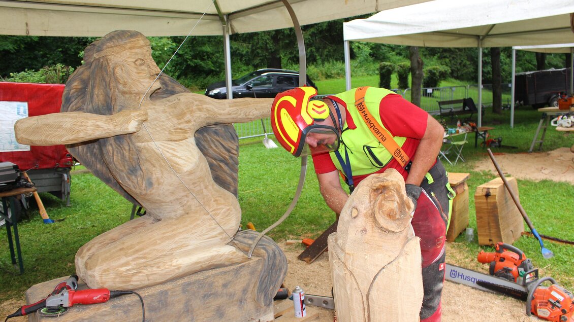 Künstler bearbeitet mit einer Motorsäge eine Holzskulptur bei den Kettensägen-Kunstschnitztagen in Voitsberg. | © Robert Cescutti