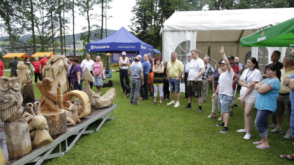 Besucher betrachten geschnitzte Holzfiguren bei den Kettensägen-Kunstschnitztagen in Voitsberg. | © Jasmin Stadler