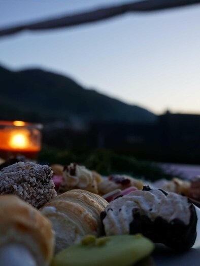 Zu sehen ist ein Teller mit Kuchen und ein Teelicht in der Dämmerung. | © Gemeinde Ratten