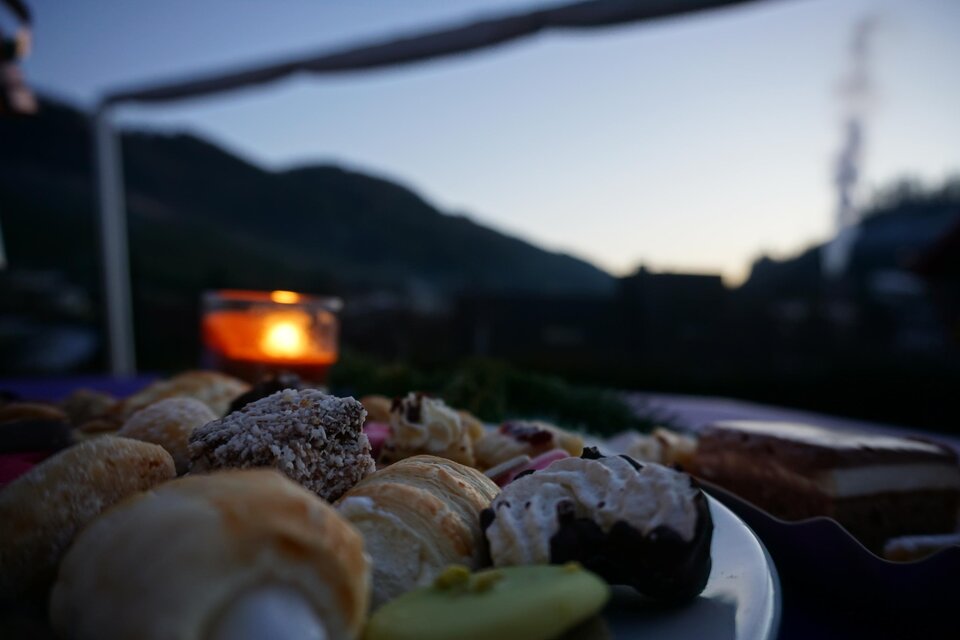 Zu sehen ist ein Teller mit Kuchen und ein Teelicht in der Dämmerung. | © Gemeinde Ratten