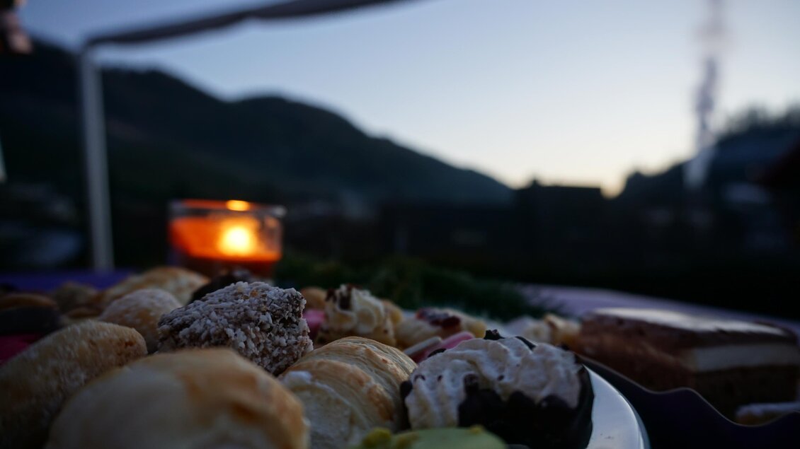 Zu sehen ist ein Teller mit Kuchen und ein Teelicht in der Dämmerung. | © Gemeinde Ratten