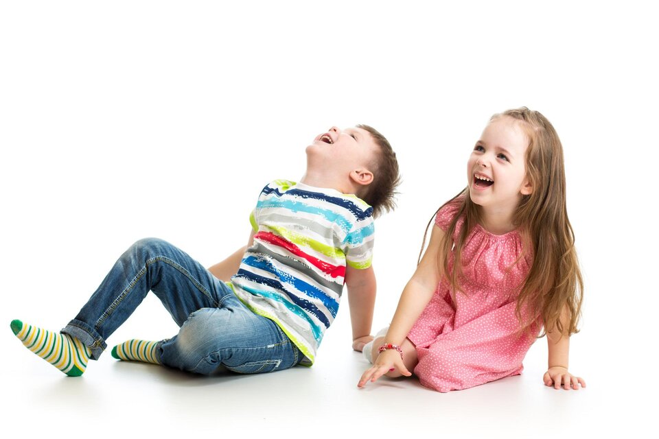Zwei Kinder lachen und sitzen auf dem Boden. Das Mädchen trägt ein pinkes Kleid und der Junge ein gestreiftes T-Shirt. | © TV Südsteiermark - Adobe Stock