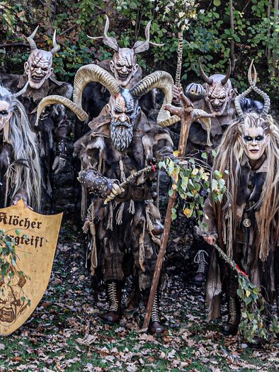 Das Foto zeigt eine eindrucksvolle Gruppe der Klöcher Burgteifl in ihren aufwendig gestalteten Masken und Kostümen. Mächtige Hörner, furchteinflößende Gesichtszüge, Fell und rustikale Gewänder sorgen für eine mystische und zugleich beeindruckende Erscheinung. Gemeinsam verkörpert die Gruppe eindrucksvoll das traditionelle Brauchtum rund um Krampus und Perchten und sorgt mit ihren detailreichen Figuren für eine ganz besondere Atmosphäre. | © Klöcher Burgteifl