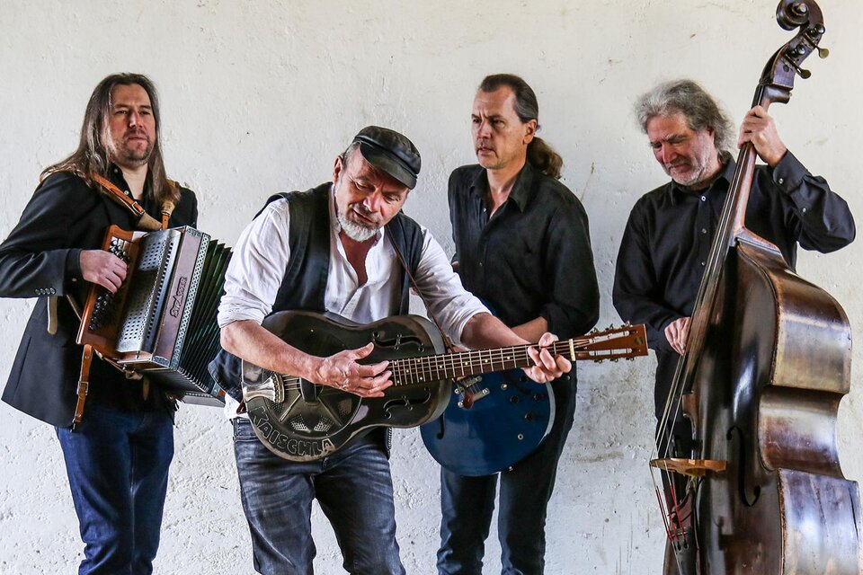 Eine Band mit vier Musikern spielt Instrumente. Sie wirken konzentriert und spielen verschiedene traditionelle Instrumente in einer hellen Umgebung. | © Reinhard Sock