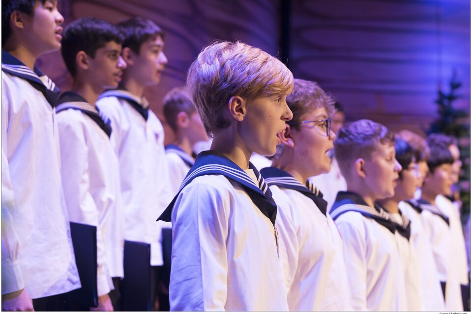 Eine Gruppe von Jungen in Matrosenanzügen singt in einem Chor. Die Szenerie ist festlich und die Jungen zeigen konzentrierte Gesichtsausdrücke. | © Lukas Beck