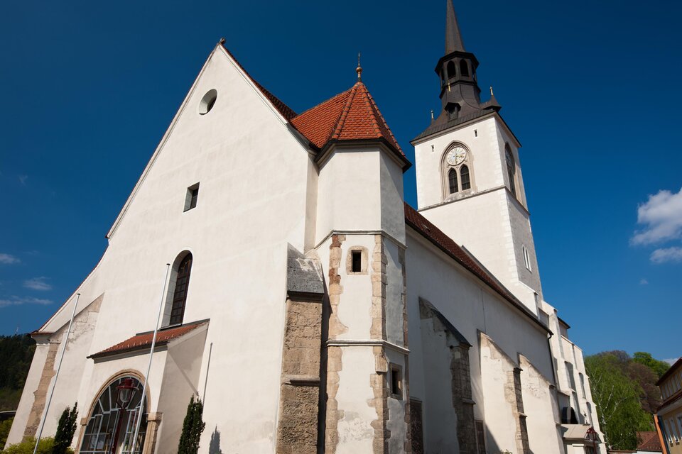 Eine elegante Kirche mit einem hohen Turm und einem roten Dach. Der Himmel ist klar und blau. | © Harry Schiffer