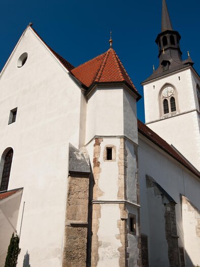 Eine elegante Kirche mit einem hohen Turm und einem roten Dach. Der Himmel ist klar und blau. | © Harry Schiffer