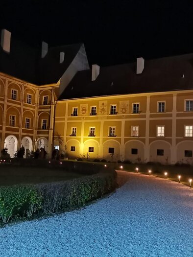 Ein historisches Gebäude mit gelber Fassade und großen Fenstern. Im Vordergrund befinden sich ein gepflegter Garten und ein gepflasterter Weg. | © TV Südsteiermark - Irene Löschnig