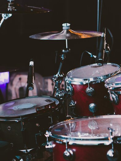 A drum set with red and black drums. The instruments are ready for a performance. | © pixabay.com