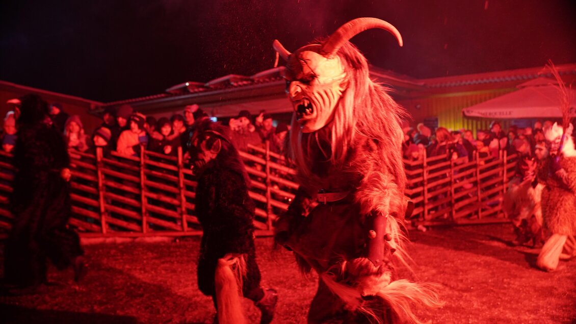 Ein Krampus mit kunstvoller Holzmaske und großen Hörnern geht mit | © Stadtgemeinde Frohnleiten
