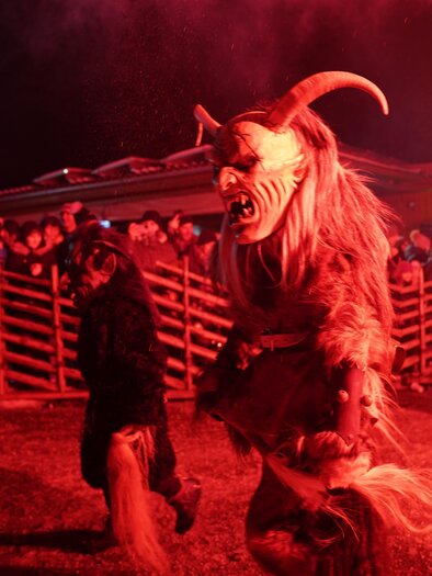 Ein Krampus mit kunstvoller Holzmaske und großen Hörnern geht mit | © Stadtgemeinde Frohnleiten