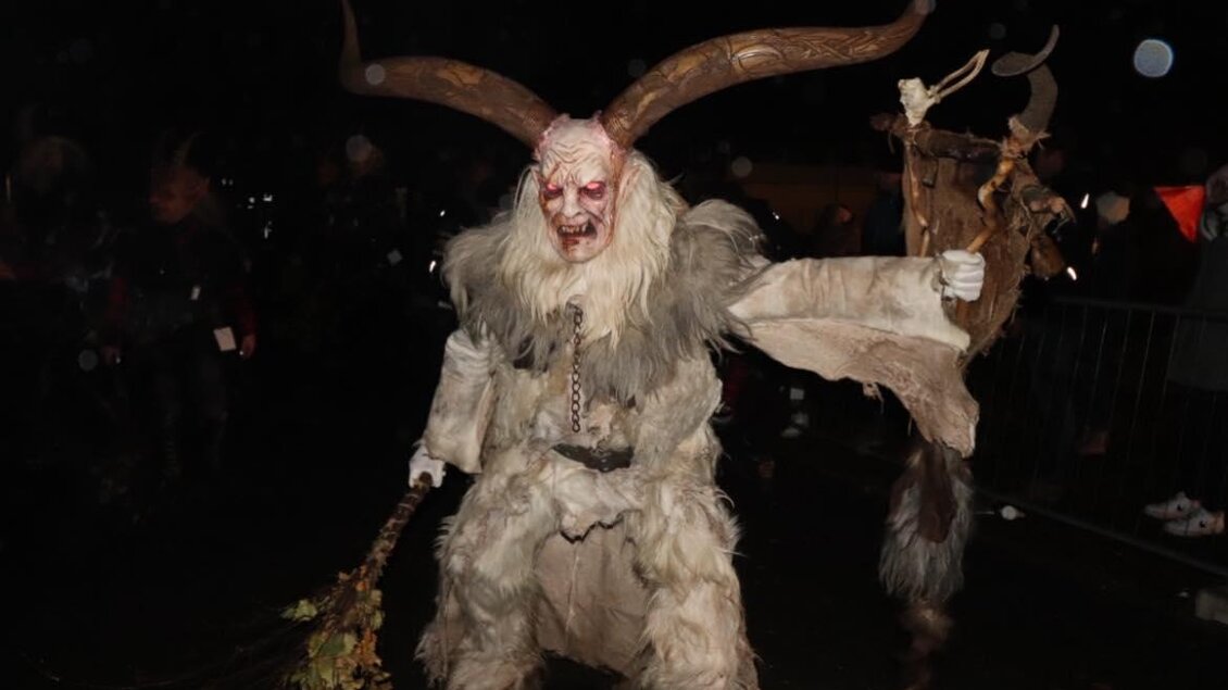Ein mysteriöser, dämonischer Charakter mit Geweihen und einem furchterregenden Gesicht. Er trägt ein zotteliges Kostüm und hält einen Besen in der Hand. | © Stoarbruch Teifl| Krampuslauf