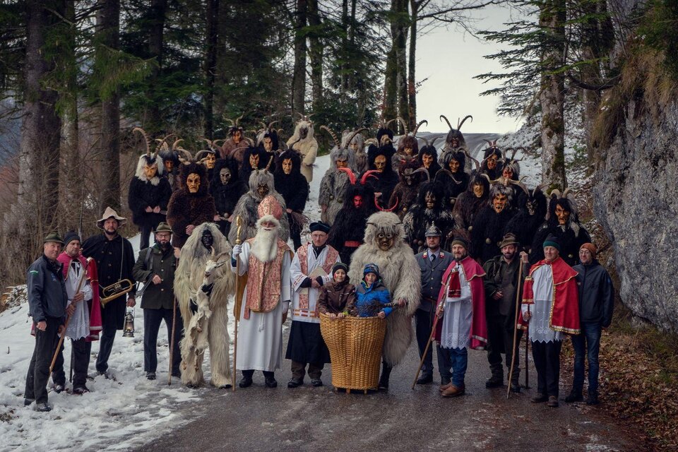 Gruppenbild der Nikologruppe Kumitz auf der Einfahrt zum Kumitzberg. In der ersten Reihe stehen die lichten Gesellen des Nikolaus, dahinter die dunklen Krampusse mit ihren unterschiedlichen Masken. | © Lebensbilder - Christine Struz