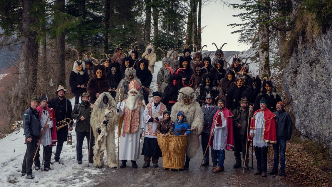 Gruppenbild der Nikologruppe Kumitz auf der Einfahrt zum Kumitzberg. In der ersten Reihe stehen die lichten Gesellen des Nikolaus, dahinter die dunklen Krampusse mit ihren unterschiedlichen Masken. | © Lebensbilder - Christine Struz