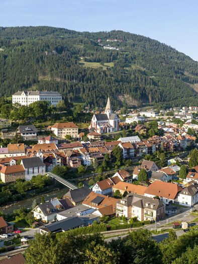 Eine malerische Stadt mit bunten Häusern und sanften Hügeln im Hintergrund. Die idyllische Landschaft bietet eine ruhige Atmosphäre und viel Grün. | © Steiermark Tourismus