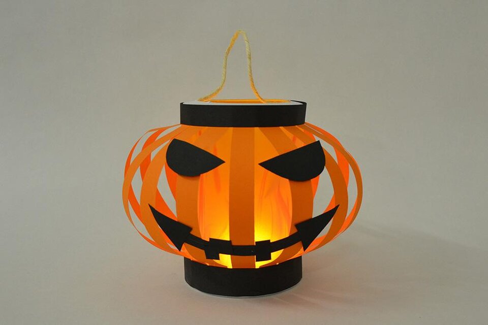 Eine Halloweenlaterne in Form eines Kürbisses. Sie ist orange mit schwarzen Augen und einem grimmigen Gesicht, und leuchtet von innen. | © KulturQuartier Leoben