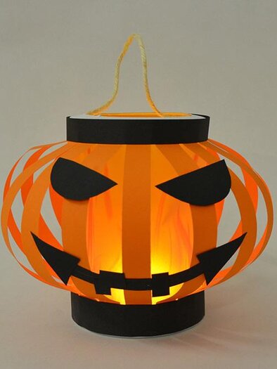 Eine Halloweenlaterne in Form eines Kürbisses. Sie ist orange mit schwarzen Augen und einem grimmigen Gesicht, und leuchtet von innen. | © KulturQuartier Leoben