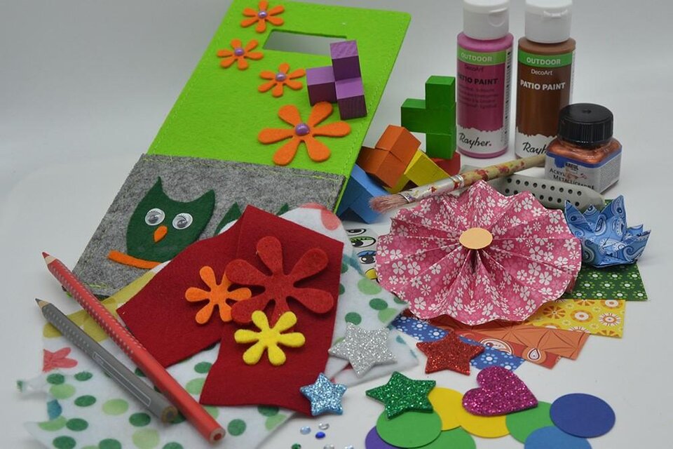 Verschiedene Bastelmaterialien liegen auf einem Tisch. Dazu gehören bunte Papiere, Farben, Scheren und Dekorationselemente. | ©  KulturQuartier Leoben