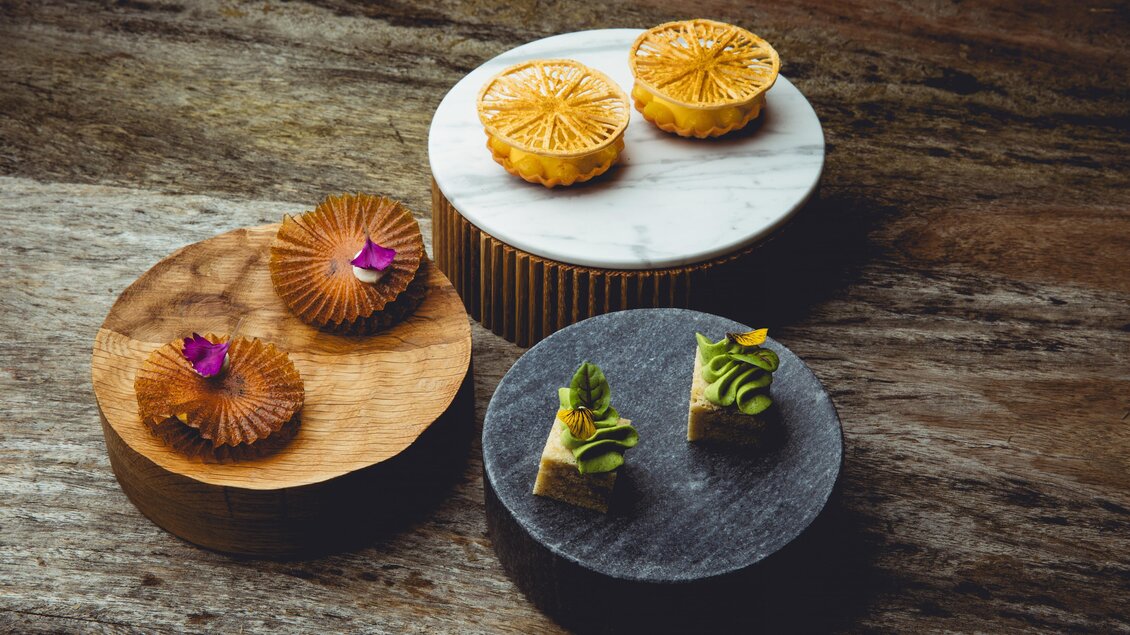 Drei kunstvoll angerichtete Desserts auf Podesten bei Fine Dining in Graz. | © Pixelcoma-Cliff Kapatais