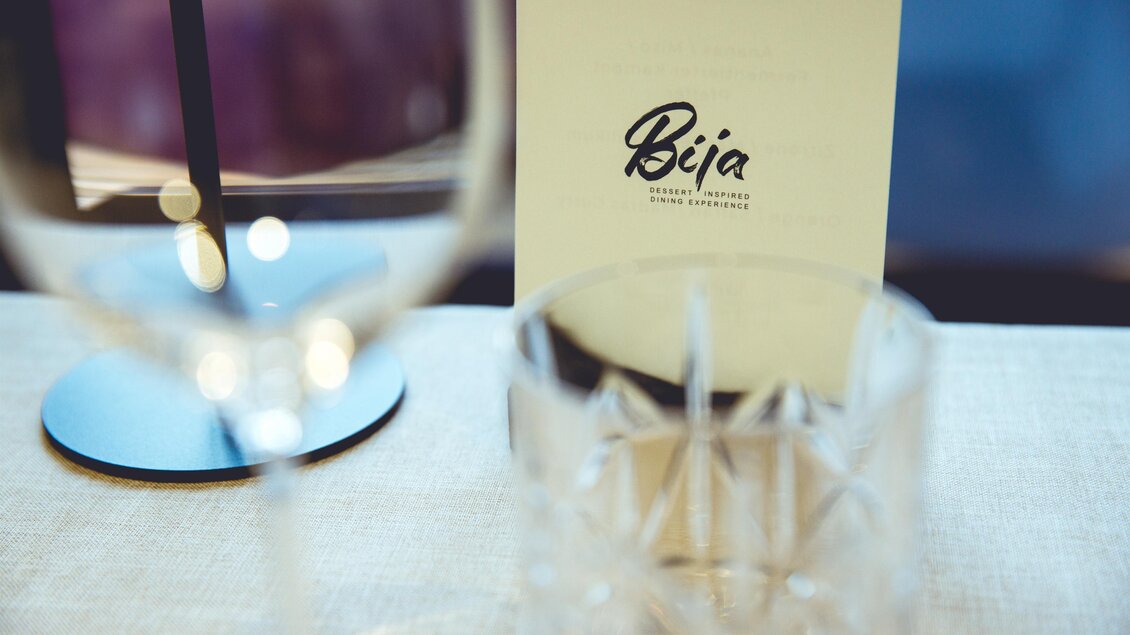 Gedeckter Tisch mit Gläsern und Menükarte bei Fine Dining Erlebnis in Graz. | © Pixelcoma-Cliff Kapatais