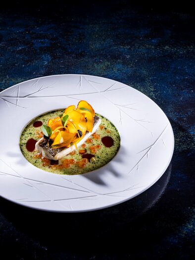 Elaborately arranged dish on a white plate with vegetables and herbs. | © Werner Krug