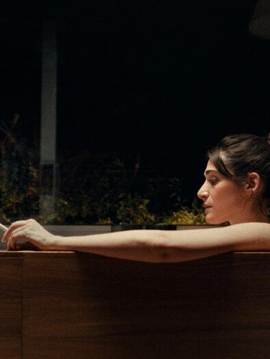 Eine Frau entspannt in einer Badewanne und schaut nachdenklich. Im Hintergrund sind Pflanzen sichtbar, was eine ruhige Atmosphäre schafft. | © Filmladen Filmverleih GmbH