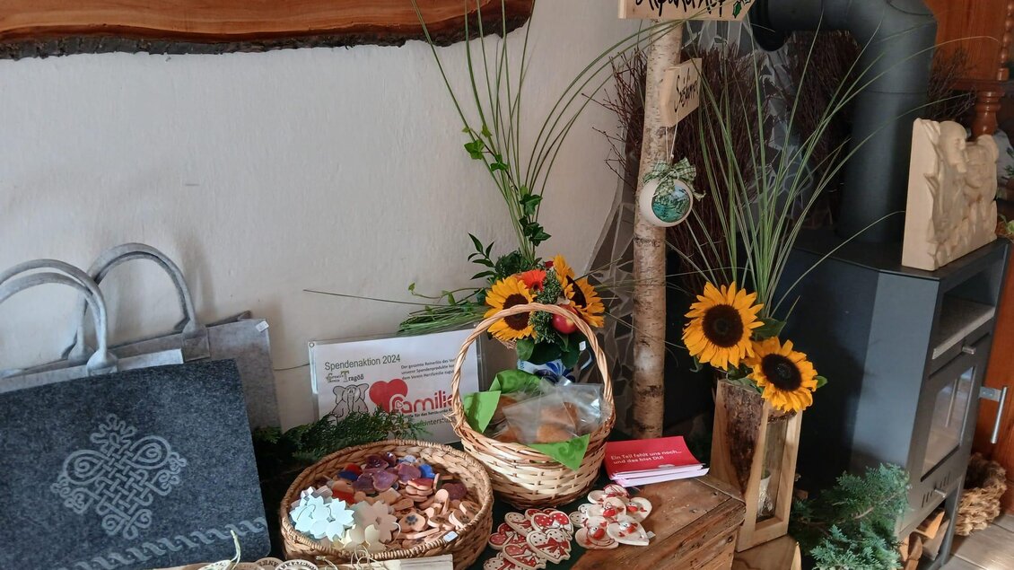 Ein dekorativer Tisch mit verschiedenen handgemachten Produkten und Geschenkkörben. Sonnenblumen und Pflanzen ergänzen die freundliche Atmosphäre. | © Michelle Friedam