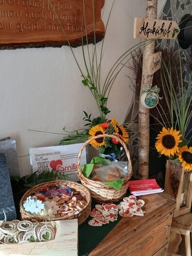 A decorative table with various handmade products and gift baskets. Sunflowers and plants enhance the friendly atmosphere. | © Michelle Friedam