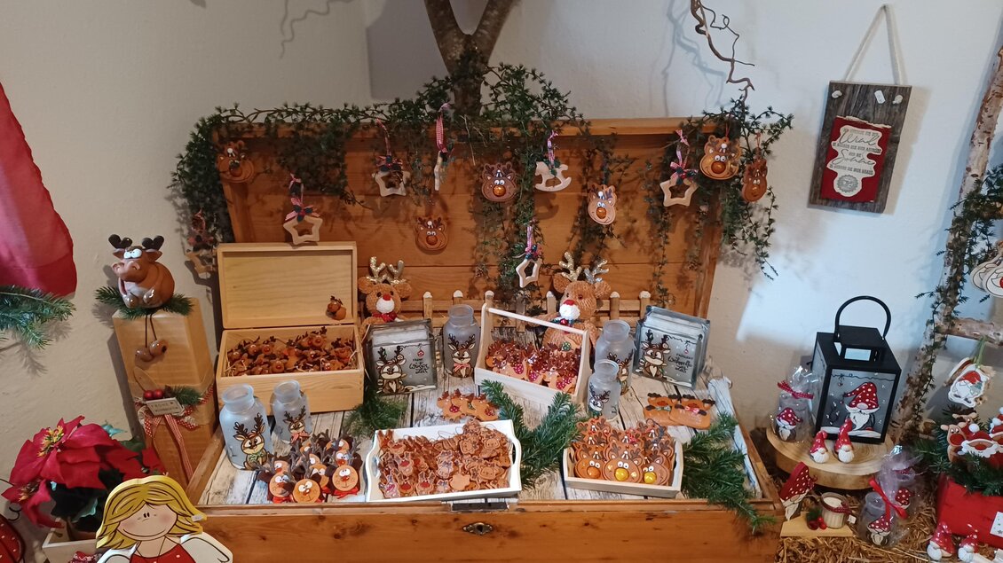 Eine festliche Dekoration mit verschiedenen Weihnachtsplätzchen und handgemachten Ornamenten. Die Präsentation ist von natürlichem Grün umgeben und strahlt Weihnachtsstimmung aus. | © Creativ Verein Tragöß