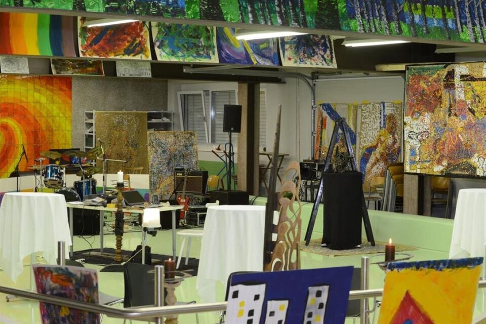 Ein Kunstraum mit mehreren Gemälden an den Wänden und Tischen in der Mitte. Es gibt eine farbenfrohe Atmosphäre mit verschiedenen Kunstwerken und kreativen Materialien sichtbar. | © Christian Koschar