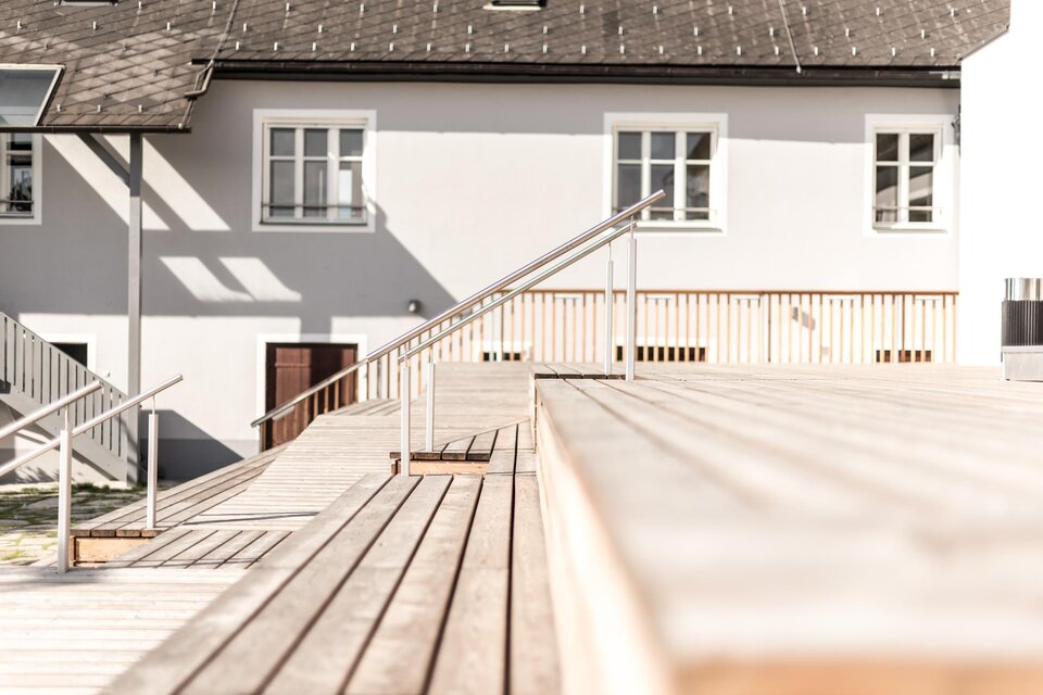 Ein schmaler Weg durch einen grünen Wald mit hohen Bäumen. Das Sonnenlicht fällt sanft auf den Weg und die Umgebung ist ruhig und friedlich. | © Stieglerhaus Blendpunkt