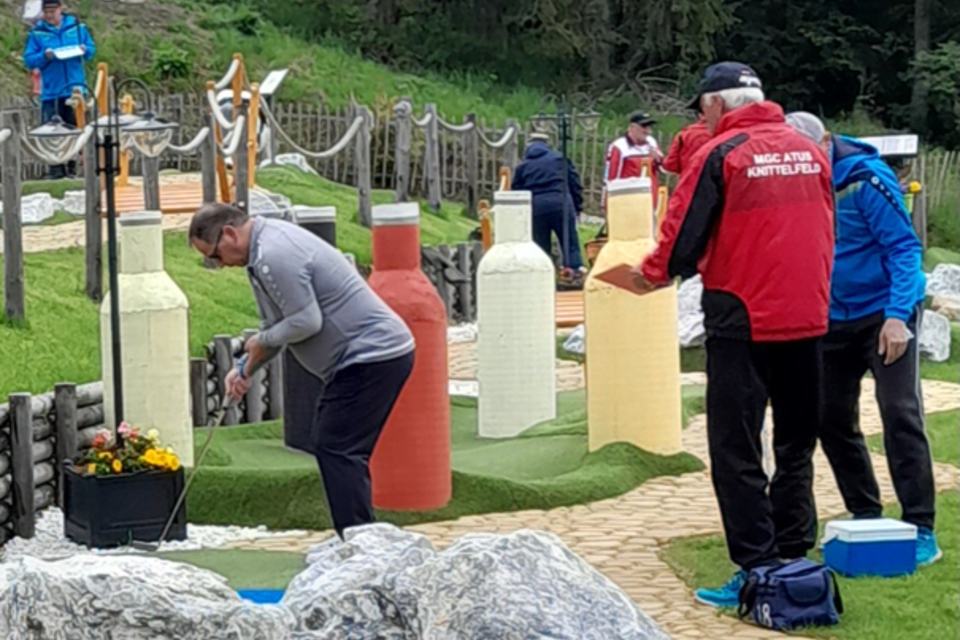Eine Minigolfanlage mit großen, bunten Flaschen als Hindernisse. Spieler versuchen, den Ball ins Ziel zu bringen. | © MountainAdventureGolf