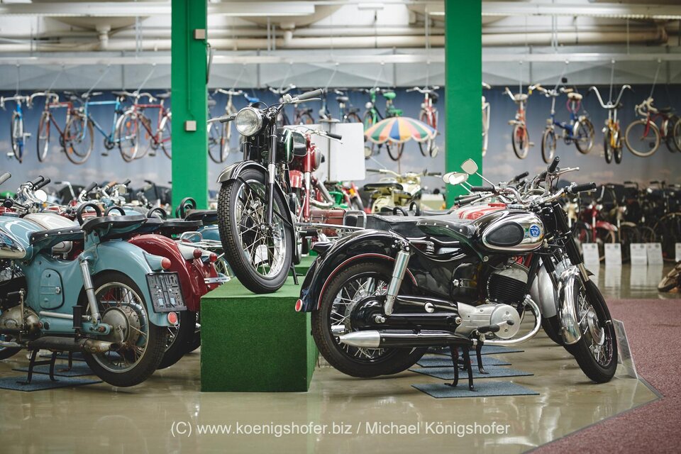 Zwei klassische Fahrzeuge stehen in einem Ausstellungsraum. Auf der linken Seite ein grüner Geländewagen und rechts ein kleiner, robuster Offroader. | © Erlebnisregion Murtal