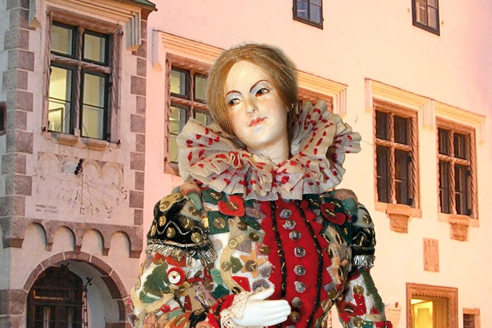 Eine kunstvolle Figur in historischer Kleidung vor einer alten Gebäudearchitektur. Die Details des Kostüms sind farbenfroh und opulent gestaltet. | © Kammerhofmuseum Bad Aussee