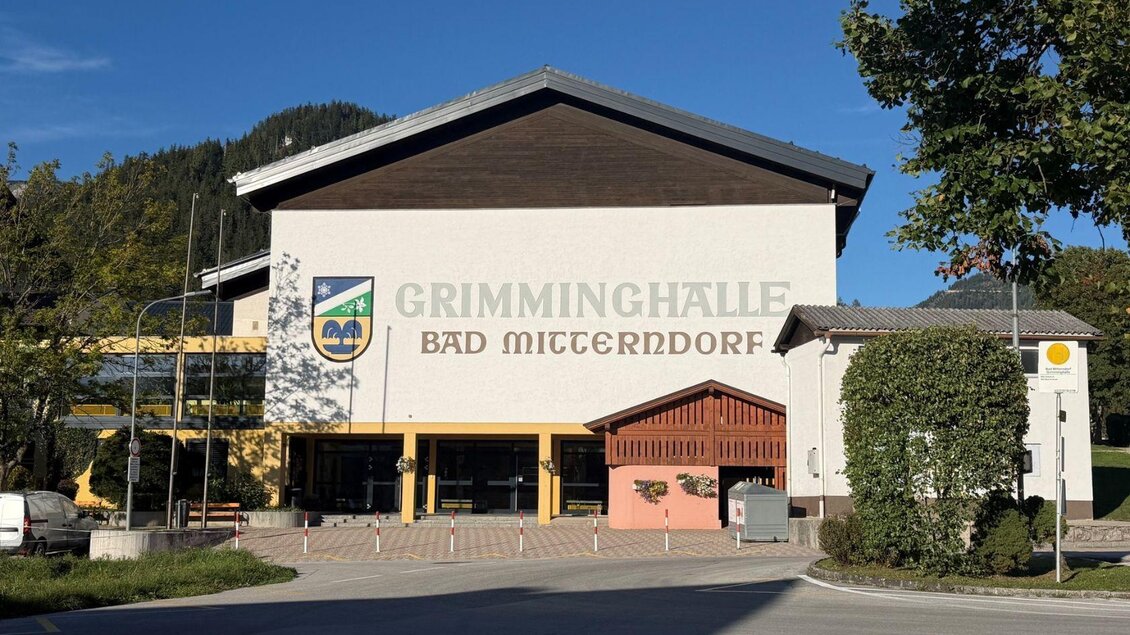 Frontansicht der Grimminghalle Bad Mitterndorf an einem sommerlichen Abend mit blauem Himmel. | © Bernadette Maria Schranz